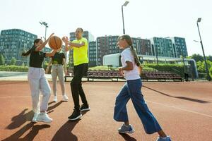 a família tocam basquetebol em a quadra foto