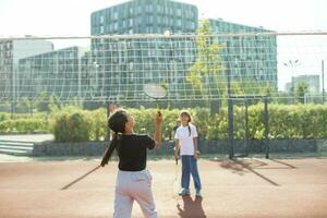 dois meninas com badminton raquetes em a futebol campo. foto