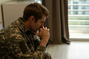 nervoso masculino militares sofrimento depressão, sentado sozinho às lar, ptsd conceito. foto