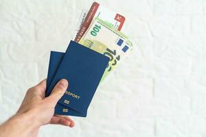 Passaporte e dinheiro com homem de negocios mão foto