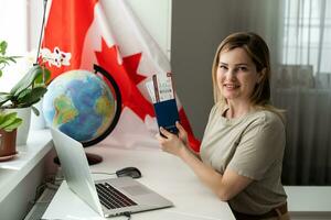 lindo jovem mulher com bandeira do Canadá mostrando polegar para cima foto