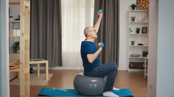 Senior homem com vitalidade exercício usando halteres dentro vivo sala. velho pessoa pensionista saudável Treinamento cuidados de saúde esporte às lar, exercício ginástica atividade às idosos era foto