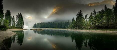nascer do sol sobre a lago com névoa dentro a montanhas foto