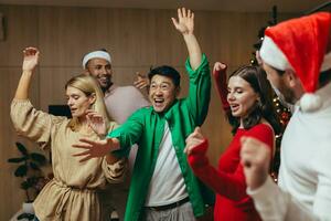 Natal festa do amigos, diverso companhia do homens e mulheres dançando às casa e a comemorar a Novo ano perto a Natal árvore, tendo Diversão dentro a tarde. foto