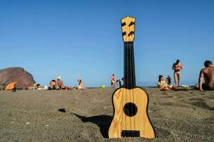 uma de madeira ukulele em a de praia foto