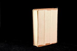 uma livro com uma branco cobrir sentado em uma Preto superfície foto