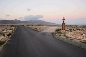 uma estrada e placa dentro a deserto foto