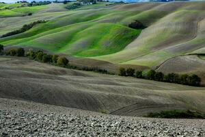 colhido Campos e prados panorama dentro toscana, Itália. ondulado país cenário às outono pôr do sol. arável terra pronto para a agrícola temporada. foto