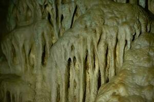 a caverna é cársico, surpreendente Visão do estalactites e estalagnites iluminado de brilhante luz, uma lindo natural atração dentro uma turista lugar. foto