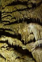 a caverna é cársico, surpreendente Visão do estalactites e estalagnites iluminado de brilhante luz, uma lindo natural atração dentro uma turista lugar. foto