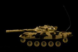 uma brinquedo tanque é mostrando contra uma Preto fundo foto