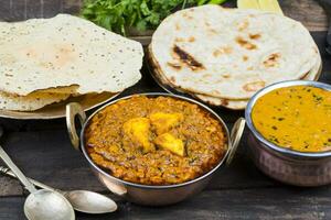 indiano Comida Kadai paneer servido com Dal Makhani, tandoori ou papad em de madeira fundo foto