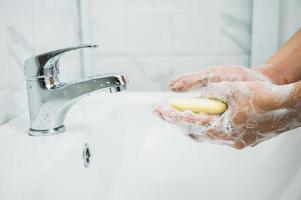 Feche as mãos masculinas lavando as mãos com sabonete foto