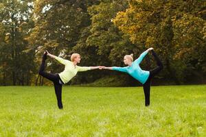 dois mulher fazendo ioga dentro natureza. foto