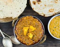 indiano Comida Kadai paneer servido com Dal Makhani, tandoori ou papad em de madeira fundo foto