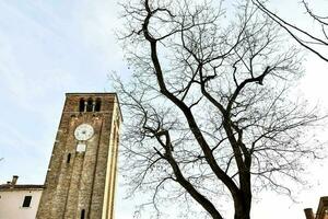 uma alta relógio torre dentro a meio do uma cidade foto