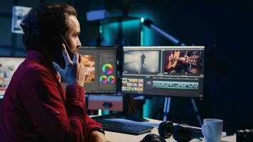 vídeo editor recebendo telefone ligar enquanto arranjo gravado estoque clipes para dentro desatado todo dentro criativo meios de comunicação estúdio. cinegrafista falando com diretor em Smartphone enquanto montagem gravado cenas foto