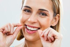 mulher limpeza dentes com dental fio dental foto