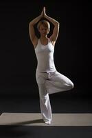 mulher exercício ioga interior em Preto fundo, foto