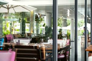 hotel restaurante espaço com mesas conjunto para jantar às luxo recorrer, Visão através de janela. foto