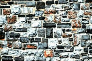 uma parede fez do pedra com muitos diferente cores foto