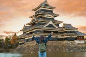 mulher turista visitando dentro matsumoto, feliz viajante passeios turísticos Matsumoto castelo ou Corvo castelo. ponto de referência e popular para turistas atração dentro matsumoto, Nagano, Japão. viagem e período de férias conceito foto