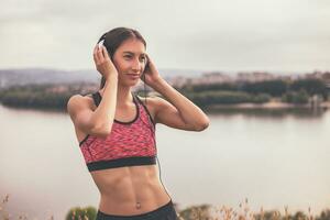 desportivo mulher goza exercício e ouvindo música. foto