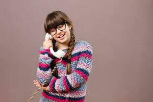 pequeno nerd menina em a telefone foto