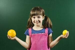 litlle menina segurando frutas foto