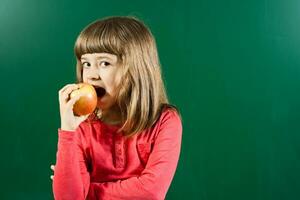 pequeno menina comendo maçã foto
