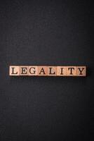 a inscrição legalidade em de madeira cubos em uma Sombrio concreto fundo foto