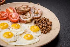 delicioso nutritivo café da manhã do frito Codorna ovos, bacon, legumes e cereja tomates foto