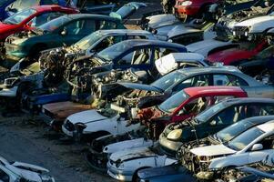 uma ampla número do estragado carros dentro uma muitos foto