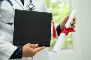 estudo de médico asiático aprende com chapéu de graduação na enfermaria do hospital, conceito de medicina de educação de gênio brilhante inteligente. foto