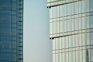 vidro construção com transparente fachada do a construção e azul céu. estrutural vidro parede refletindo azul céu. abstrato moderno arquitetura fragmento. contemporâneo arquitetônico fundo. foto