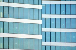 vidro construção com transparente fachada do a construção e azul céu. estrutural vidro parede refletindo azul céu. abstrato moderno arquitetura fragmento. contemporâneo arquitetônico fundo. foto