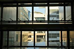 vidro construção com transparente fachada do a construção e azul céu. estrutural vidro parede refletindo azul céu. abstrato moderno arquitetura fragmento. contemporâneo arquitetônico fundo. foto