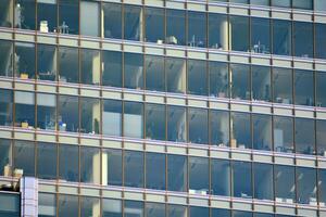 vidro construção com transparente fachada do a construção e azul céu. estrutural vidro parede refletindo azul céu. abstrato moderno arquitetura fragmento. contemporâneo arquitetônico fundo. foto