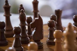 close up de peças de xadrez de madeira em um tabuleiro de xadrez de madeira