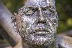 rosto quebrado em uma estátua em um parque, escultura antiga na Tailândia foto