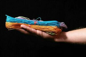uma pessoa segurando uma pilha do colorida corda foto