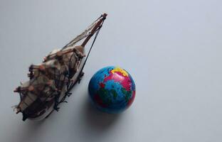 em branco para cartões e fundos com uma globo e uma modelo do a velho fragata em uma branco superfície foto