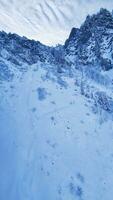 livre foto Alto ângulo tiro do uma lindo montanha alcance coberto com neve debaixo a azul céu