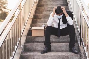 Fracasso asiático empresário desempregado estressado sentado na escada