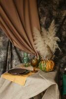 outono interior. uma mesa coberto com pratos, abóboras, uma relaxado composição do japonês pampas grama. interior dentro a foto estúdio. fechar - acima do uma decorado outono mesa.