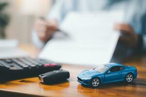 brinquedo carro dentro frente do homem de negocios calculando empréstimo. salvando dinheiro para carro conceito, comércio carro para dinheiro conceito, finança conceito. foto