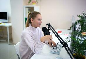 jovem mulher é transmissão enquanto sentado dentro coworking às a computador foto