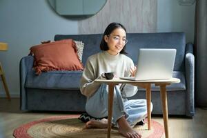 retrato do jovem trabalhando mulher, coreano menina estudando em controlo remoto on-line, falando para computador portátil, vídeo bater papo, tem conversação através da computador inscrição foto