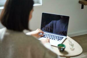 traseiro Visão do mulher, digitando e trabalhando em computador portátil, computador tela é esvaziar para cópia de espaço, fêmea aluna estudando remotamente foto