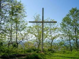 Cruz entre a árvores religioso símbolo. Cruz em a colina. foto